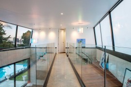 Concrete and glass bridge connects the kids' bedrooms with the master wing