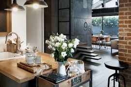 Custom crafted concrete panels, brick wall and lighting add industrial charm to the apartment