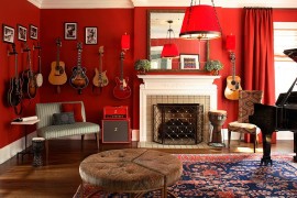 Dramatic living room in red with guitars on the walls [Design: Dillard Pierce Design Associates]