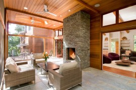 Elegant stone fireplace for the sunroom in wood and glass
