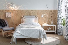 Elegant wooden bakdrop and TISDAG floor lamp create a refined ambiance in this small bedroom setup