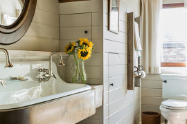 Gorgeous attic bathroom with wood ceiling and brick floor