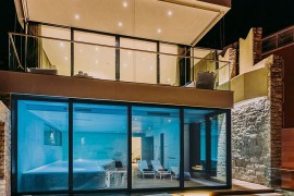 Indoor pool with retractable glass doors and lovely lighting