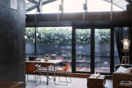 Large windows with dark frames lead to the private balcony