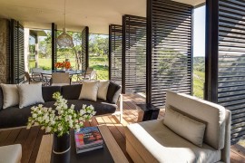 Lovely sitting area and dining space for sunroom with wooden shutters