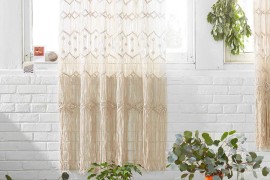 Macrame wall hanging against a white brick wall