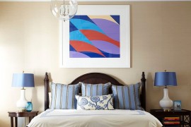 One bedside table stores books while the other showcases a sleeker frame