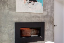 Precast concrete living room wall holds sleek modern fireplace and wall art