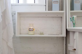 Small bright and airy bathroom with a painted brick wall