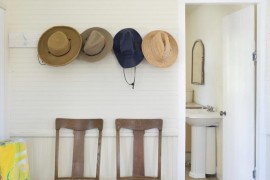 Wall-mounted hooks over a pair of entryway chairs