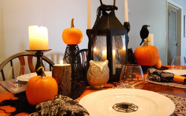 Adorable black and orange Halloween dinner setting with pumpkins, crows, owls