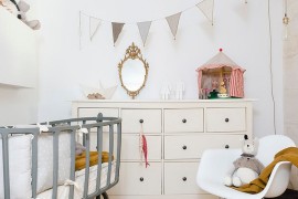 Beautiful bassinet and Eames Rocker add to Scandinavian style of the room