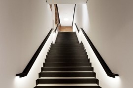 Black and white staircase with lighting along railings