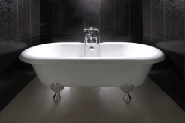 Clawfoot bathtub in a black powder room