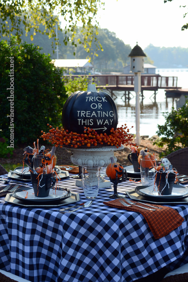 Cute outdoor Halloween table setting with black pumpkin centerpiece