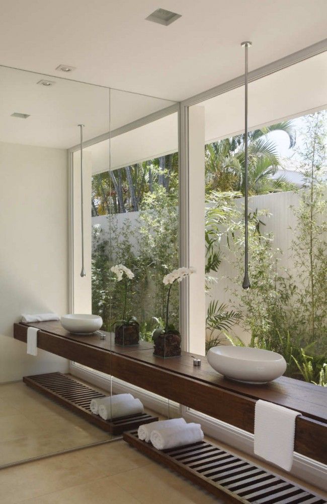Earthy modern bathroom overlooking tropical plants