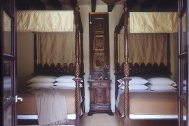 Elegant four post twin beds with a touch of gold