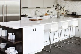 Elegant white kitchen island with dark, open shelves