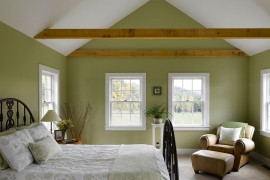 Farmhouse style bedroom in white and green with wooden beams