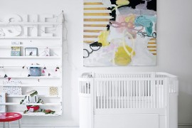 Large wall art adds color to the all-white nursery