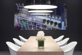 Minimal wooden table, black oversized pendants and brilliant artwork shape lovely dining area