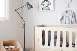 Monochromatic nursery with floor lamp and a contemporary crib