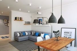 Oversized floor lamp and pendant lights in gray play into the color scheme of the Scandinavian living room
