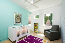 Scandinavian nursery with turquoise accent wall, brick wall and purple rug