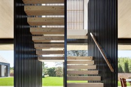 Sculptural steel and wooden staircase of the barn-style home
