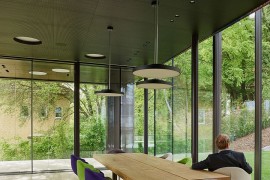 Wooden top dining table with metal legs and colorful chairs around it