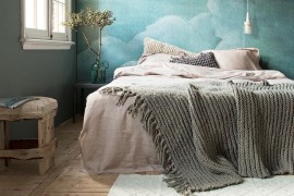 Bedroom with bright blue cloud wallpaper