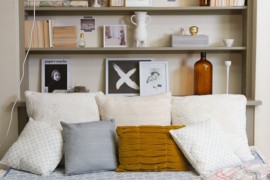 Bookshelf with bed positioned up against it from one side
