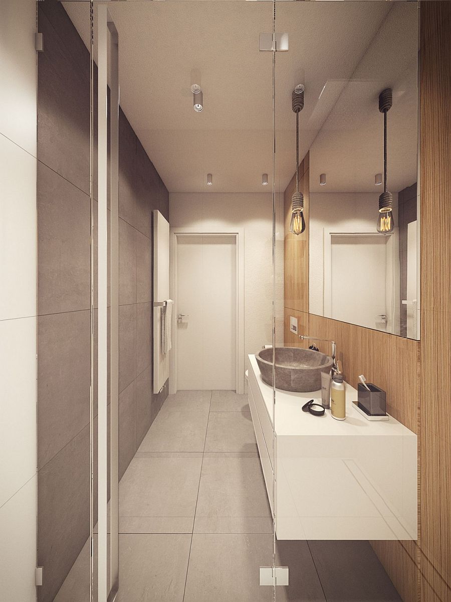Exposed concrete surfaces and edison bulb lighting create a cool bathroom