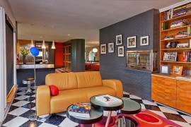 Gray painted brick wall with fireplace and a display of family photos [Design: The Funky Umbrella]