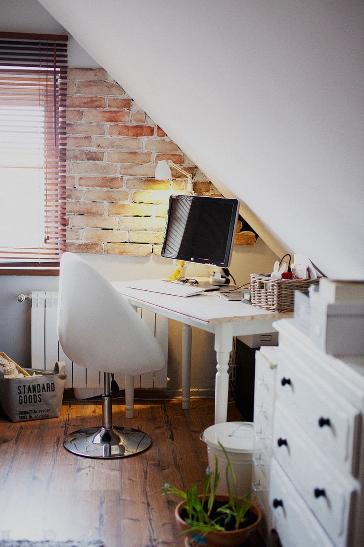 Home office nook in an attic with partial brick wall