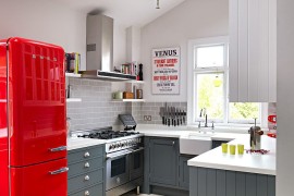 Kitchen cabinets in Mercury by Fired Earth complement the splash of red!