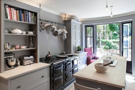 Mixed cabinet styles coupled with open gray shelves give the kitchen a modern appeal