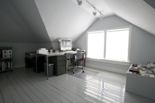 Office desk next to a huge attic window