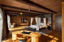 Reading nook and home workspace occupy the opposite corners of the lavish bedroom