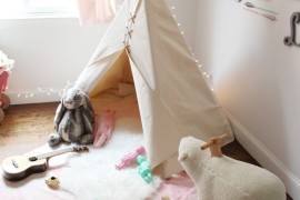 Simple white teepee with lots of toys nearby to play with