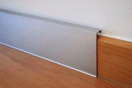 Sleek aluminum baseboard beautifully offsets wood flooring