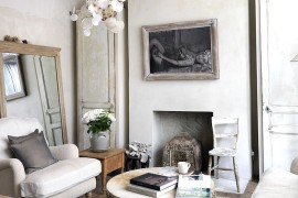 Tree trunk coffee and antique mirror epitomize the shabby chic style of the room