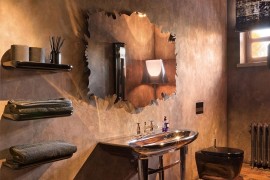 Unique bathroom mirror ends up being the showstopper in the tuscan styled space