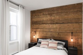 Wall of original wooden boards creates a lovely ambiance in the bedroom