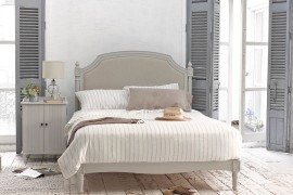 Weathered look of the flooring, shutters in gray and vintage bed usher in the shabby chic style
