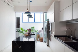 White and bright modern kitchen with dark central island and worktops in stone