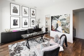 A collection of black and white framed photographs and wall add to the neutral color scheme