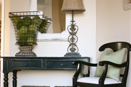 An elegant white and weathered wood mirror hung near the stairs in an entryway