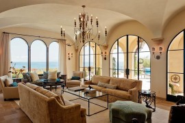 Arched windows and limestone-inspired paint give the living room a modern Mediterranean style