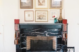 Black marble fireplace under a wall art display